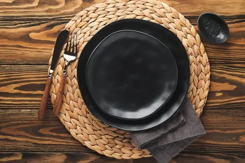 Ceramic empty black plate, silverware and linen kitchen towel napkin on old b Stock Photos