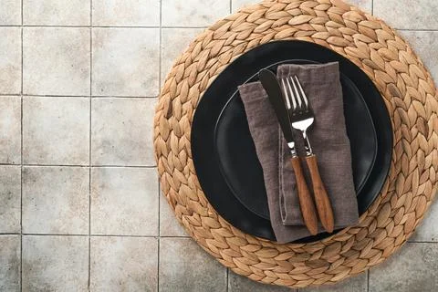 Ceramic empty black plate, silverware and linen kitchen towel napkin on old c Stock Photos
