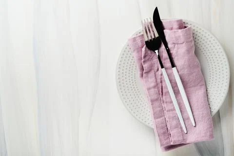 Ceramic empty white plate and pink linen kitchen towel napkin on old ceramic  Stock Photos