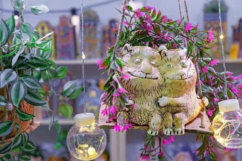 Ceramic figurines of cats in love hugging on a swing. Stock Photos