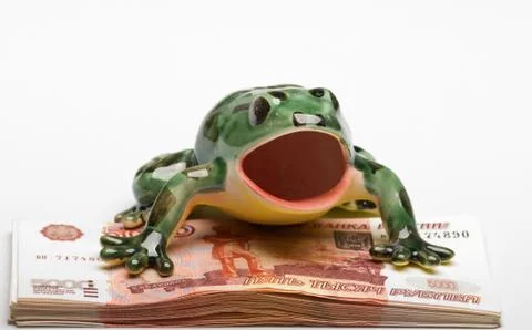 Ceramic frog on a pile of five-thousandth denominations Stock Photos