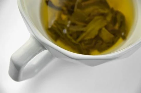 Ceramic geometry shaped gray cup of green tea on a white background Stock Photos