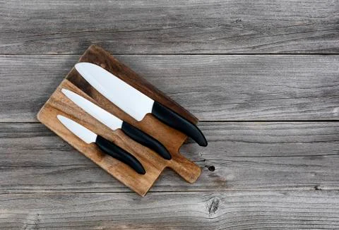 Ceramic knife set on rustic server board Stock Photos
