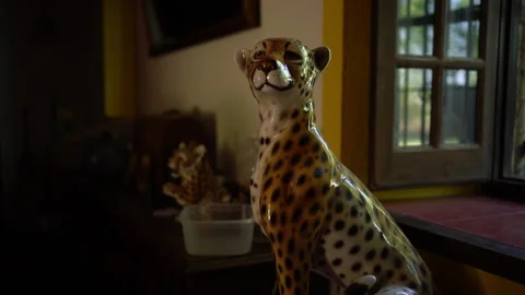 Ceramic Leopard Figurine Sits Beside a Window Indoors Video stock 343044356