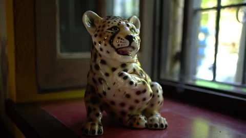 Ceramic Leopard Figurine Sits on a Windowsill Ledge Video stock 343044648