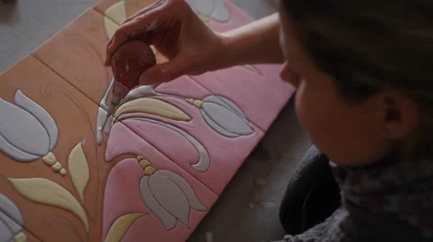 Ceramic maker filling pencil strokes on terracotta with rubber bulb Stock Footage 61948490