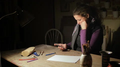 Ceramic maker writing sms in her atelier Stock Footage 61950331