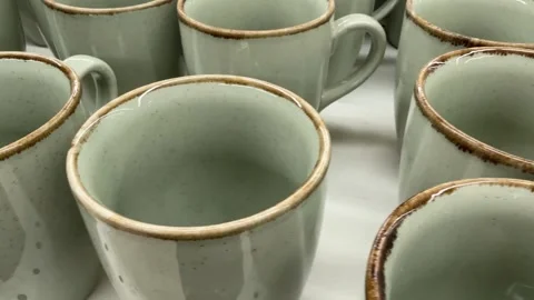 Ceramic mugs with speckled glaze and brown rim in a close-up view Stock Footage 330397127