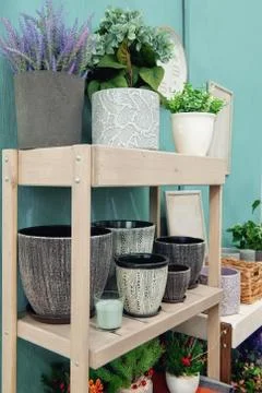 Ceramic multi-colored pots and vases for flowers on white shelves in the mark Stock Photos