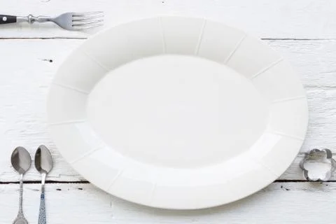 Ceramic oval dish, fork and spoons Stock Photos