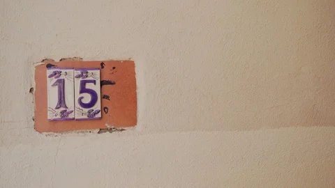 Ceramic, painted tiles with the number 15 fifteen left side on light wall 库存影片 117136579