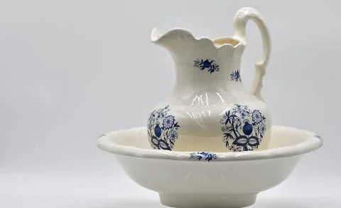 Ceramic Pitcher and Basin Set Featuring Floral Patterns Displayed on a Neut.. Stock Photos