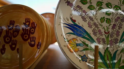 A ceramic plate with a hand-painted yellow finish features multiple reddish... Stock Footage 339313356