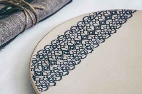 Ceramic plate with lace pattern decoration on linen table setting closeup Stock Photos