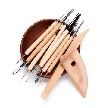 Ceramic plate with set of sculptor tools isolated on white background Stock Photos