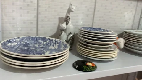 Ceramic plates and cups on a shelf in a kitchen Stock Footage 263007468