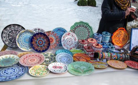 Ceramic plates, hand-painted with a dot pattern, are on the counter at the fe Stock Photos