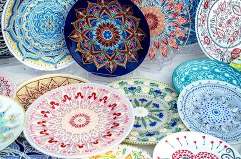 Ceramic plates, hand-painted with a dot pattern, are on the counter at the fe Stock Photos