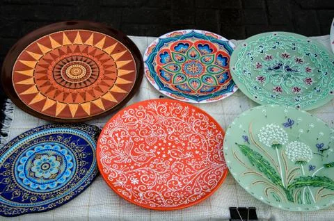 Ceramic plates, hand-painted with a dot pattern, are on the counter at the fe Stock Photos