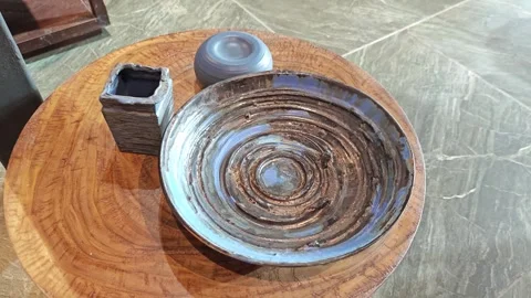 Ceramic plates on round wooden table. Stock Footage 339989713