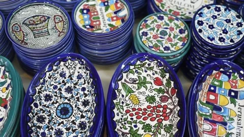 Ceramic plates with traditional national pattern lies on stall in market. Stock Footage 183990735