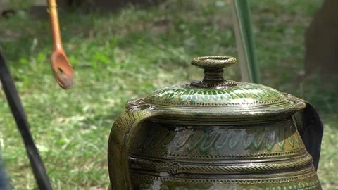 Ceramic pot set on fire on the hearth in the yard where the food boils over Stock Footage 146542561
