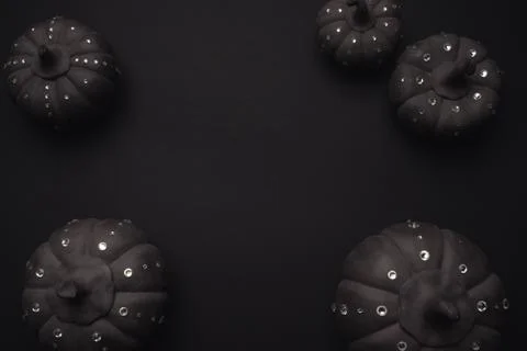 Ceramic pumpkins with rhinestones on a black background. Stock Photos