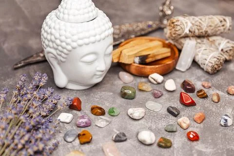 Ceramic statuette of a Buddha head. Selection of semiprecious stones. Stock Photos