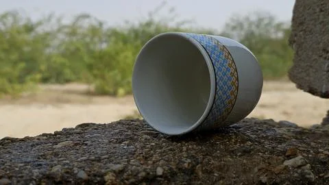 Ceramic tea cup with geometric pattern lying sideways on a stone wall Stock Photos