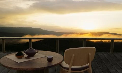 Ceramic tea set and dry tea leave on a wooden table and chair on the balcony  Stock Illustration