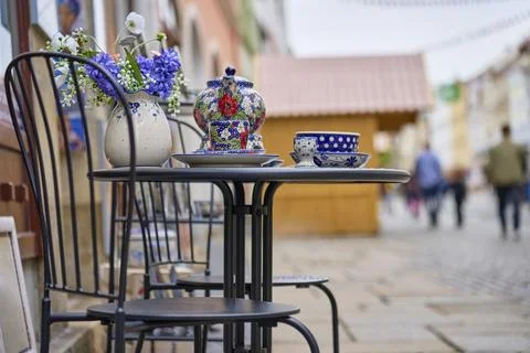 Ceramic tea set with patterned cups, plates and flower vase displayed on tabl Stock Photos