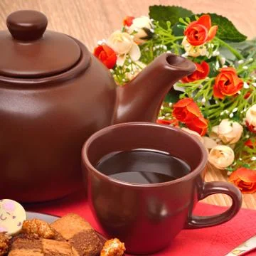 Ceramic teapot, cup and sauser with biscuits with flowers Stock Photos