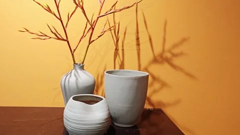 Ceramic vases with shadow on yellow wall. 스톡 동영상 339989139