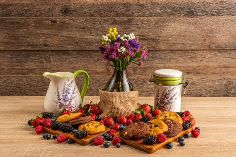 Ceramic vessels with assorted mix of forest fruits and flowers in vase Foto stock