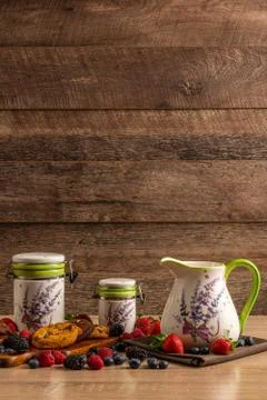 Ceramic vessels on wooden table assorted with cookies and forest fruits with Stock Photos