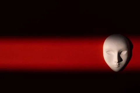 Ceramic white mask on red background with shadows Foto stock
