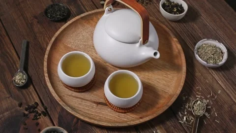 Ceramic white teapot and cups. Dried various kinds of tea on ceramic spoons. Stock Footage 204158834