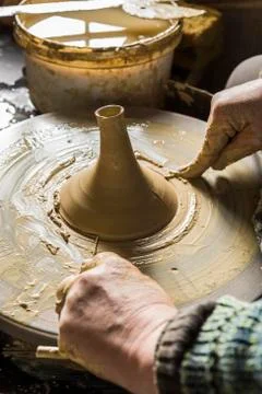 Ceramic workshop hands separating spout from pottery wheel with cutting wire Stock Photos