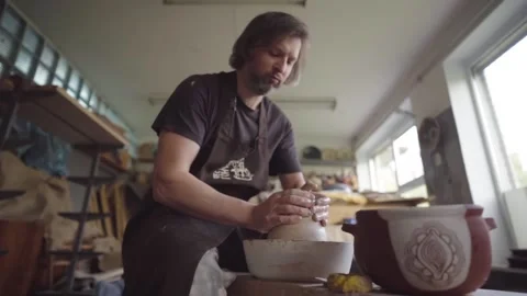 Ceramics studio. Potter at work. Clay bowl spinning on pottery wheel. 库存影片 143376970
