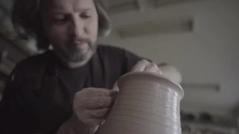 Ceramics studio. Potter at work. Clay bowl spinning on pottery wheel. Video stock 143376986