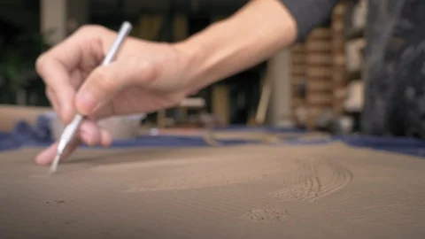 Ceramist creates a pattern and relief dolly shot Stock Footage 104870716