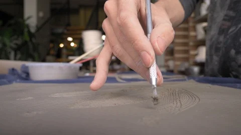 Ceramist creates a pattern and relief dolly shot Stock Footage 104870903
