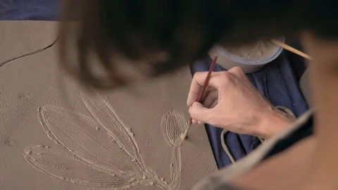 Ceramist lays out a pattern on the future vase for flowers, dolly shot Stock Footage 104882154