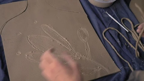 Ceramist lays out a pattern on the future vase for flowers, dolly shot Stock Footage 104882322