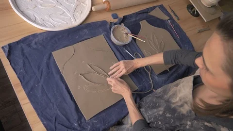 Ceramist lays out a pattern on the future vase for flowers, dolly shot Stock Footage 104882461
