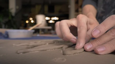 Ceramist lays out pattern on future vase flowers, dolly shot Stock Footage 104882556