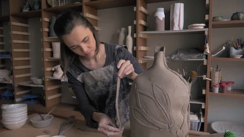 Ceramist lays out a pattern on the future vase for flowers, dolly shot Stock Footage 104882748