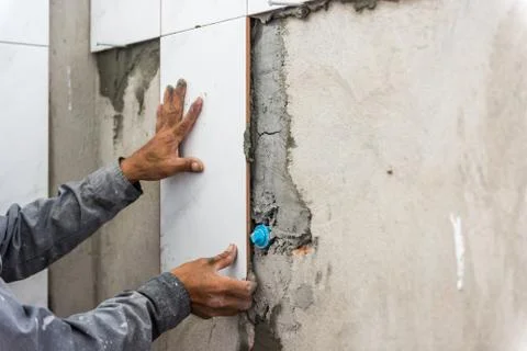 Ceramist puts tile on the wall. Professional ceramist is laying ceramic tile  Stock-Fotos