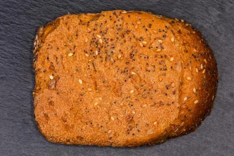 Cereal bread crust texture, view on black flat slate plate Stock Photos