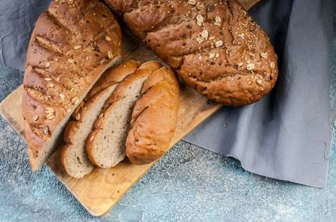 Cereal Bread Roll with various Seeds on a wooden cutting board. Top view Stock Photos